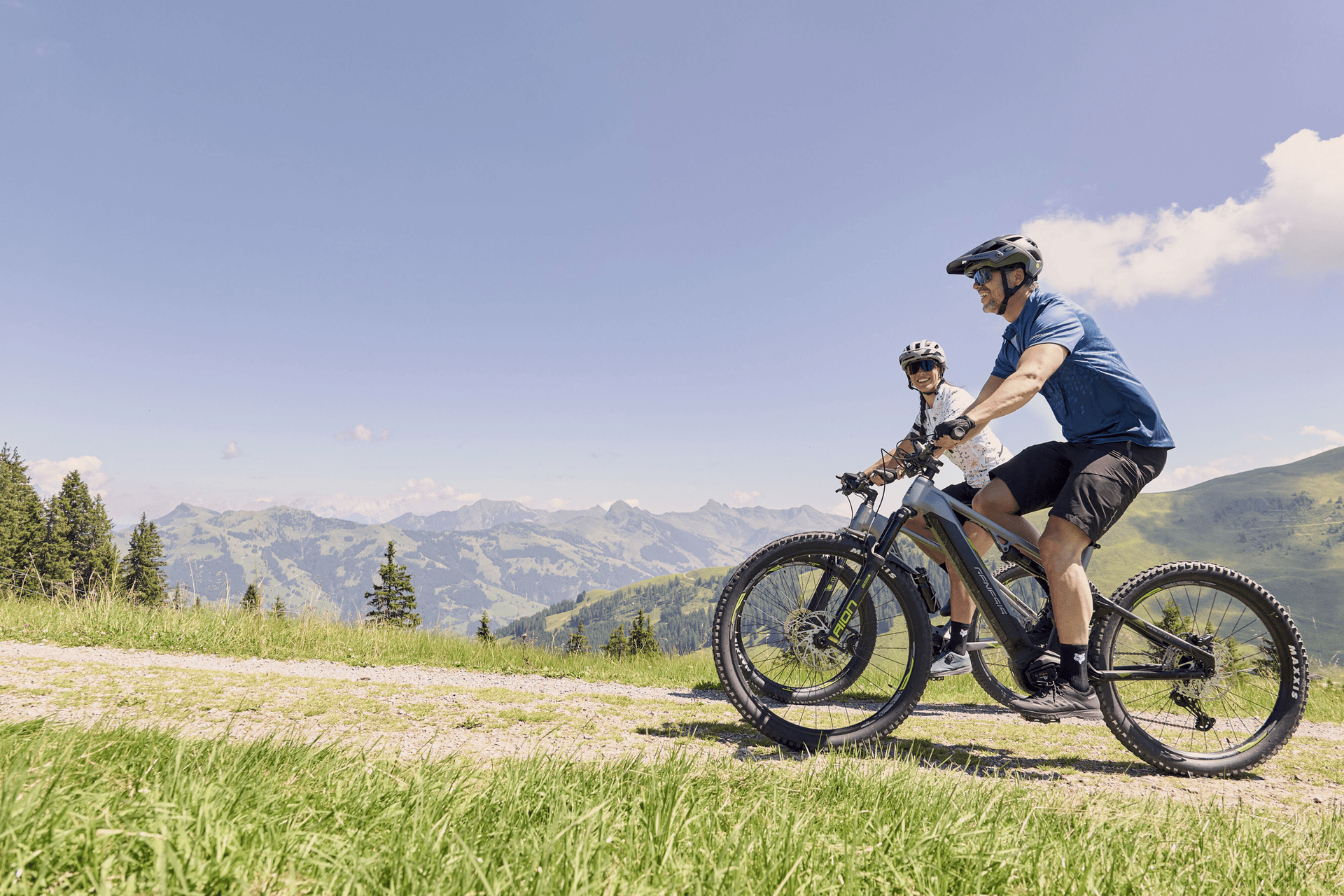 Ein Mann und eine Frau fahren mit ihrem E-Mountainbike bergauf